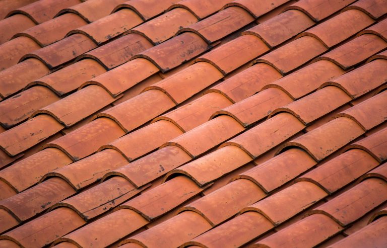 Red concrete roof tiles laid on a house roof