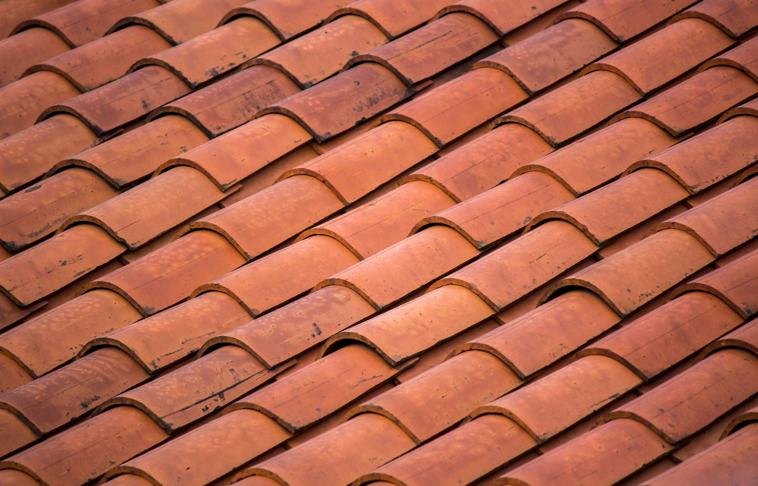 Red concrete roof tiles laid on a house roof